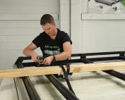 Josh securing timber to a Wedgetail Trade rack with ratchet straps