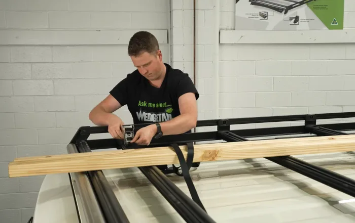 Josh securing timber to a Wedgetail Trade rack with ratchet straps